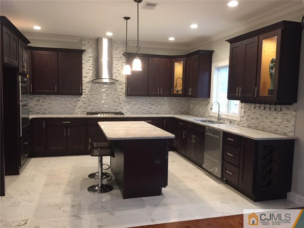 216 Oxford Road Edison, NJ 08820 - Photo 3 of 13 a kitchen with kitchen island granite countertop a sink counter top space appliances and cabinets
