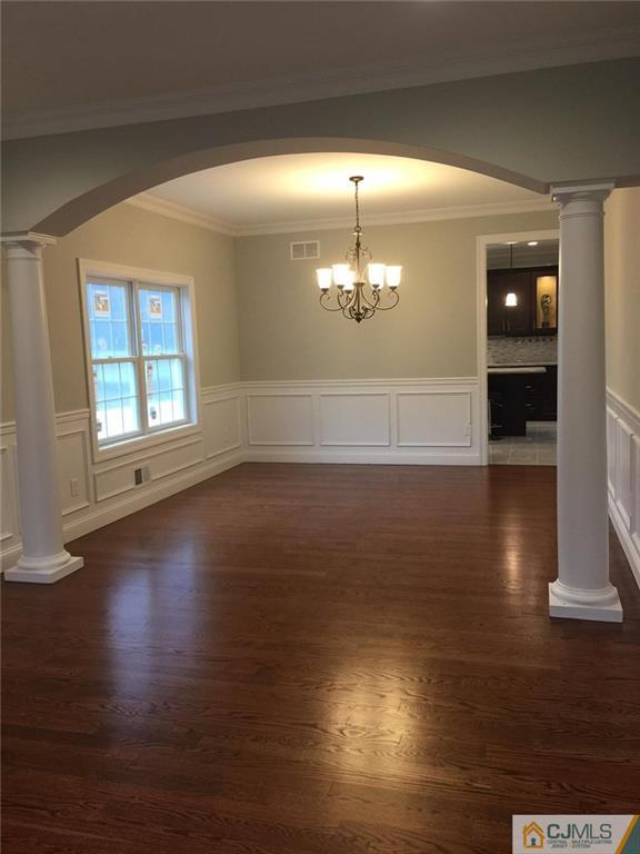 216 Oxford Road Edison, NJ 08820 - Photo 5 of 13 an empty room with wooden floor chandelier and windows