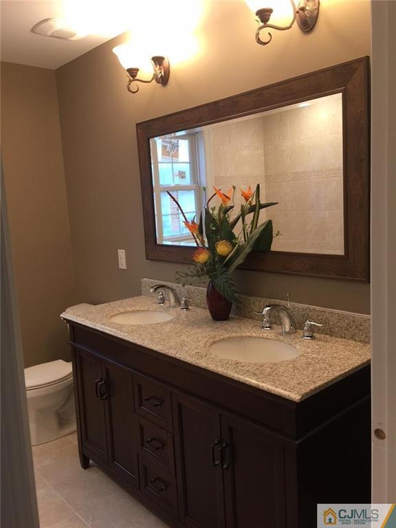 216 Oxford Road Edison, NJ 08820 - Photo 7 of 13 a bathroom with a granite countertop sink a toilet and mirror