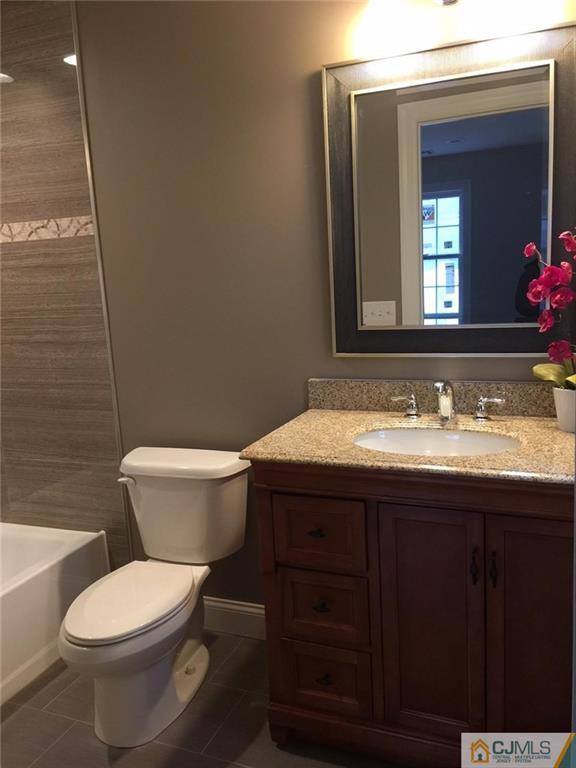 216 Oxford Road Edison, NJ 08820 - Photo 9 of 13 a bathroom with a granite countertop toilet a sink and a mirror