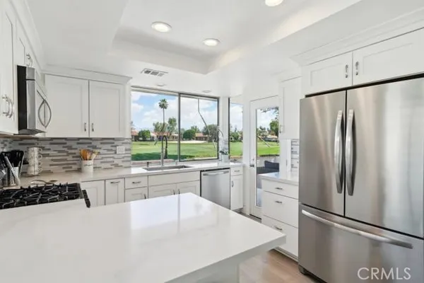 a kitchen with stainless steel appliances a refrigerator sink and cabinets
