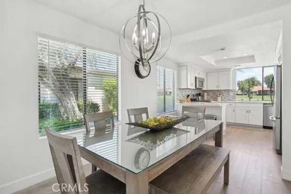 a kitchen with stainless steel appliances granite countertop a stove a table and chairs in it