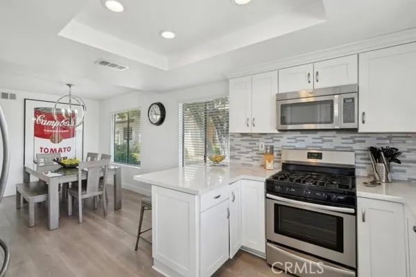 a kitchen with stainless steel appliances granite countertop a stove a sink and a microwave