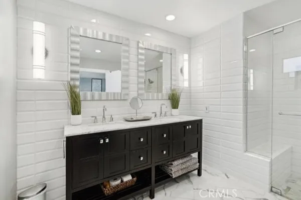 a bathroom with a double vanity sink mirror and shower
