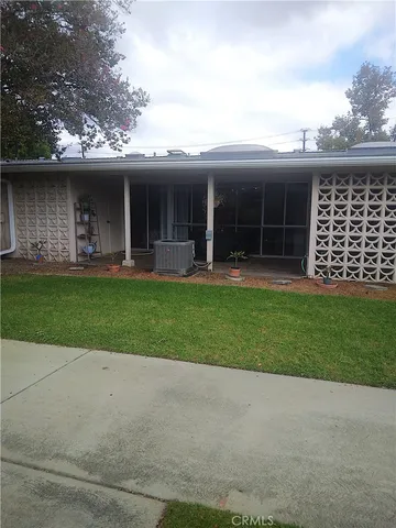 front view of a house with a yard and a large tree