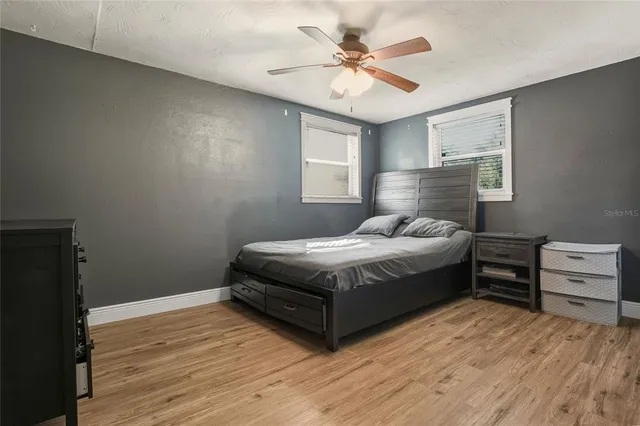 a bedroom with a bed chandelier and a window