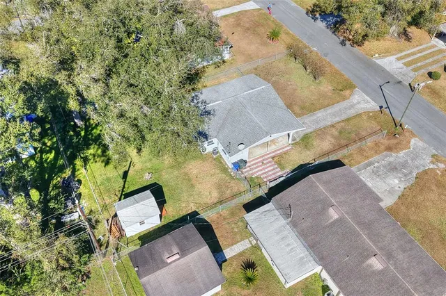 an aerial view of a house with a yard and trees