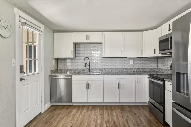 a kitchen with stainless steel appliances granite countertop a stove a sink and a refrigerator