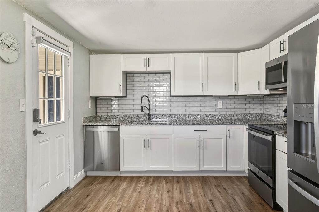 3210 Decatur Avenue Lakeland, FL 33805 - Photo 10 of 37 a kitchen with stainless steel appliances granite countertop a stove a sink and a refrigerator