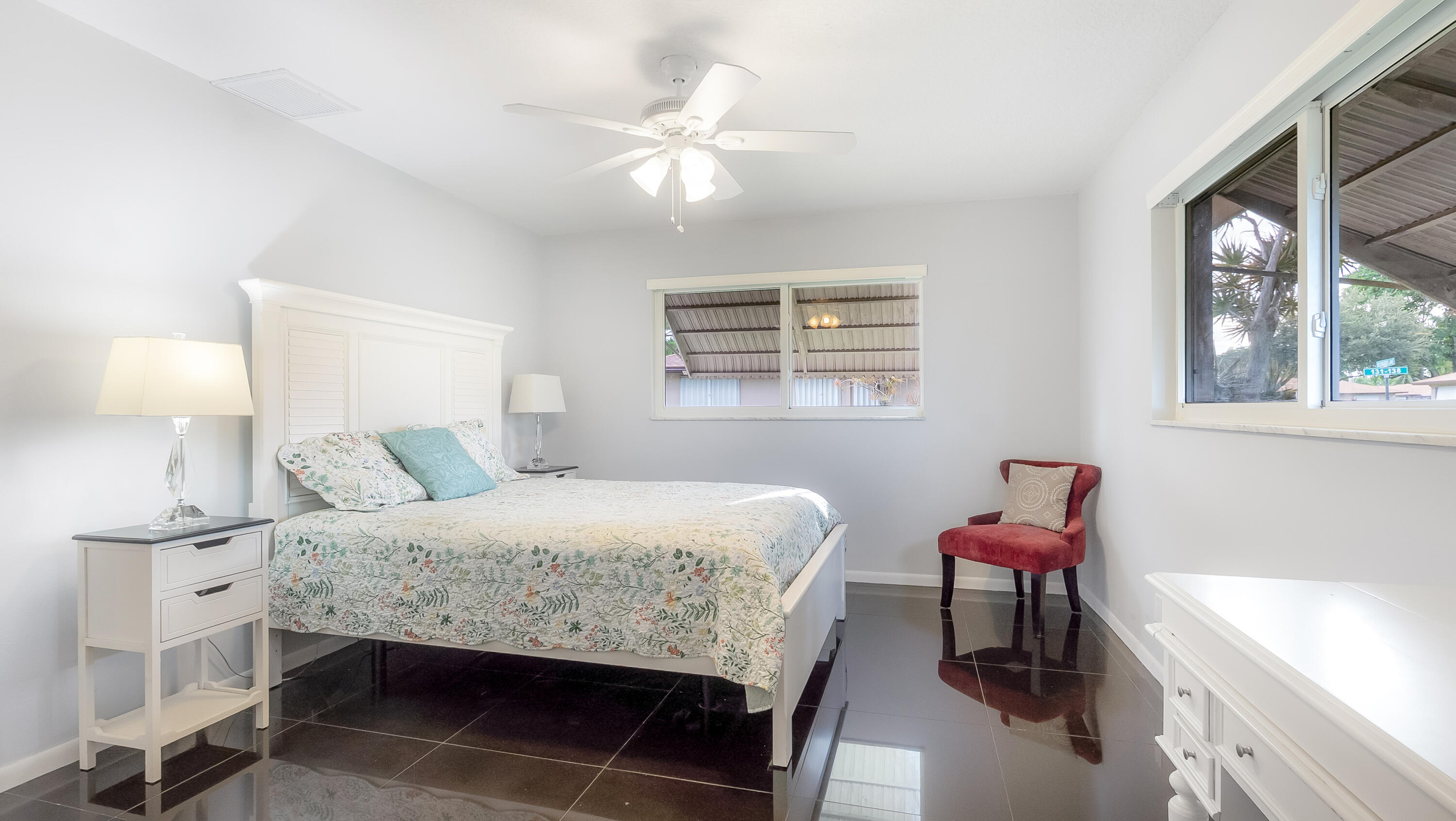 131 Mockingbird Lane Delray Beach, FL 33445 - Photo 14 of 29 a bedroom with a bed and a table in it with window