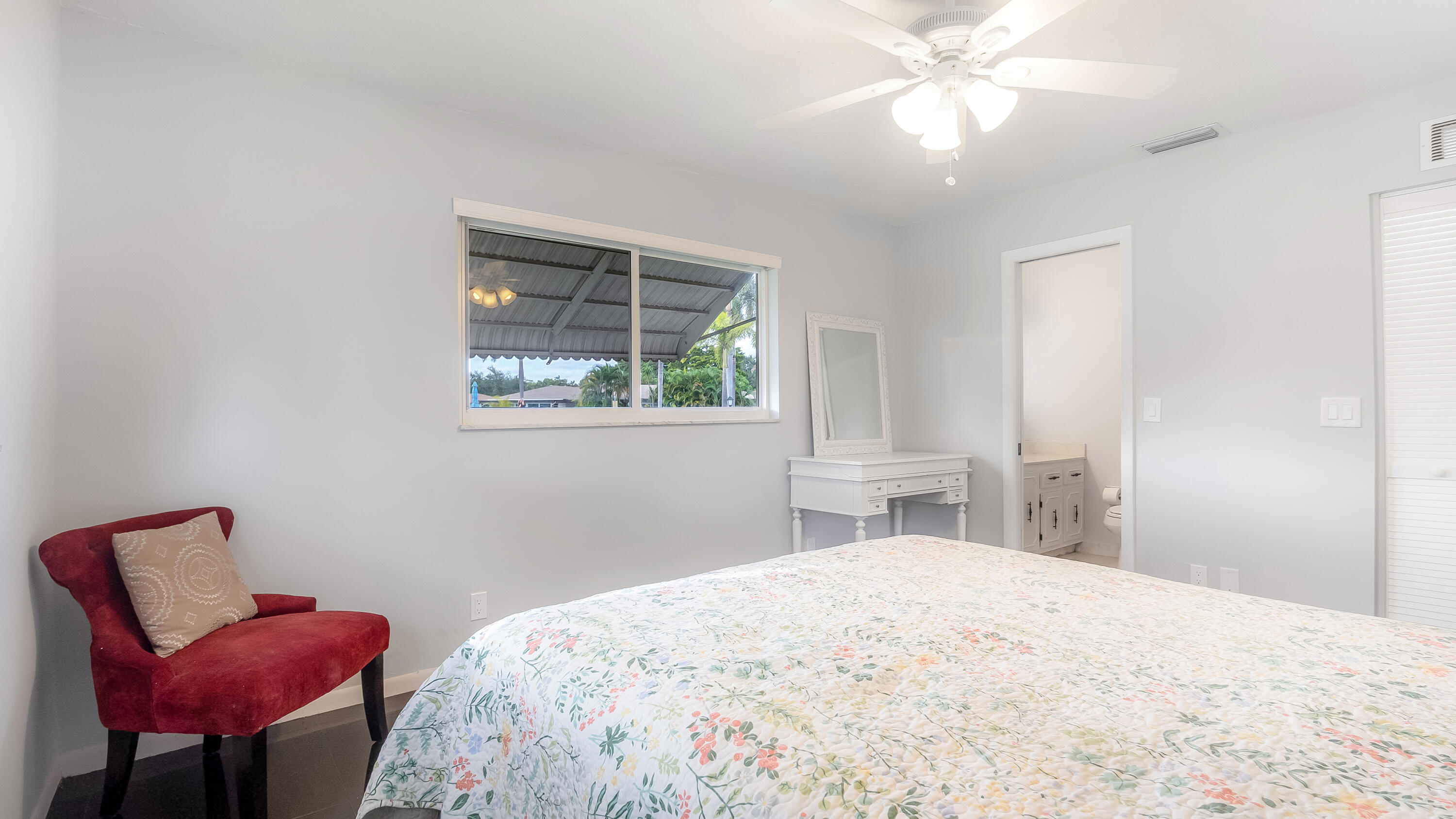 131 Mockingbird Lane Delray Beach, FL 33445 - Photo 16 of 29 a bedroom with a bed window and a chandelier