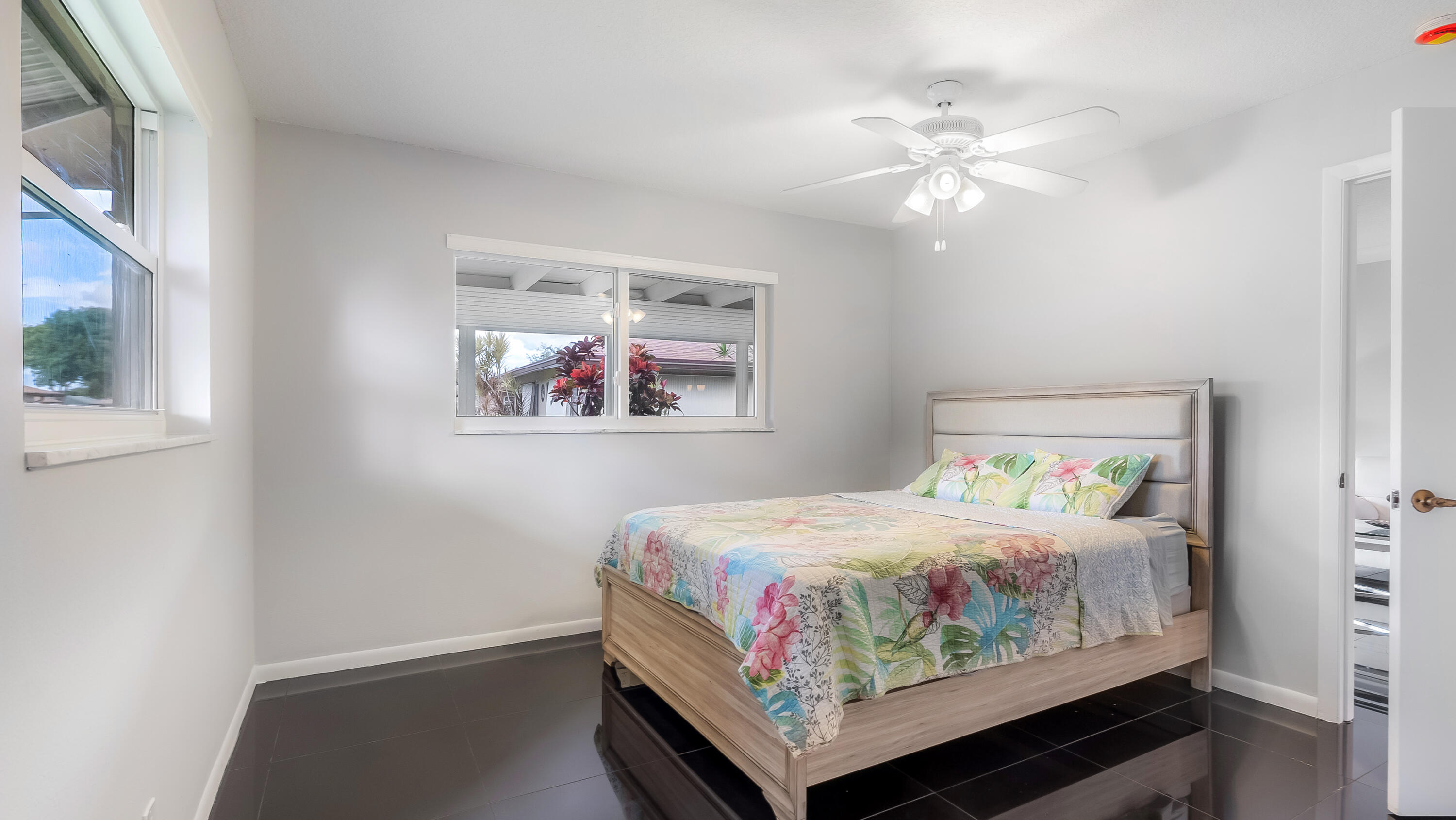 131 Mockingbird Lane Delray Beach, FL 33445 - Photo 20 of 29 a bedroom with a bed and a chandelier