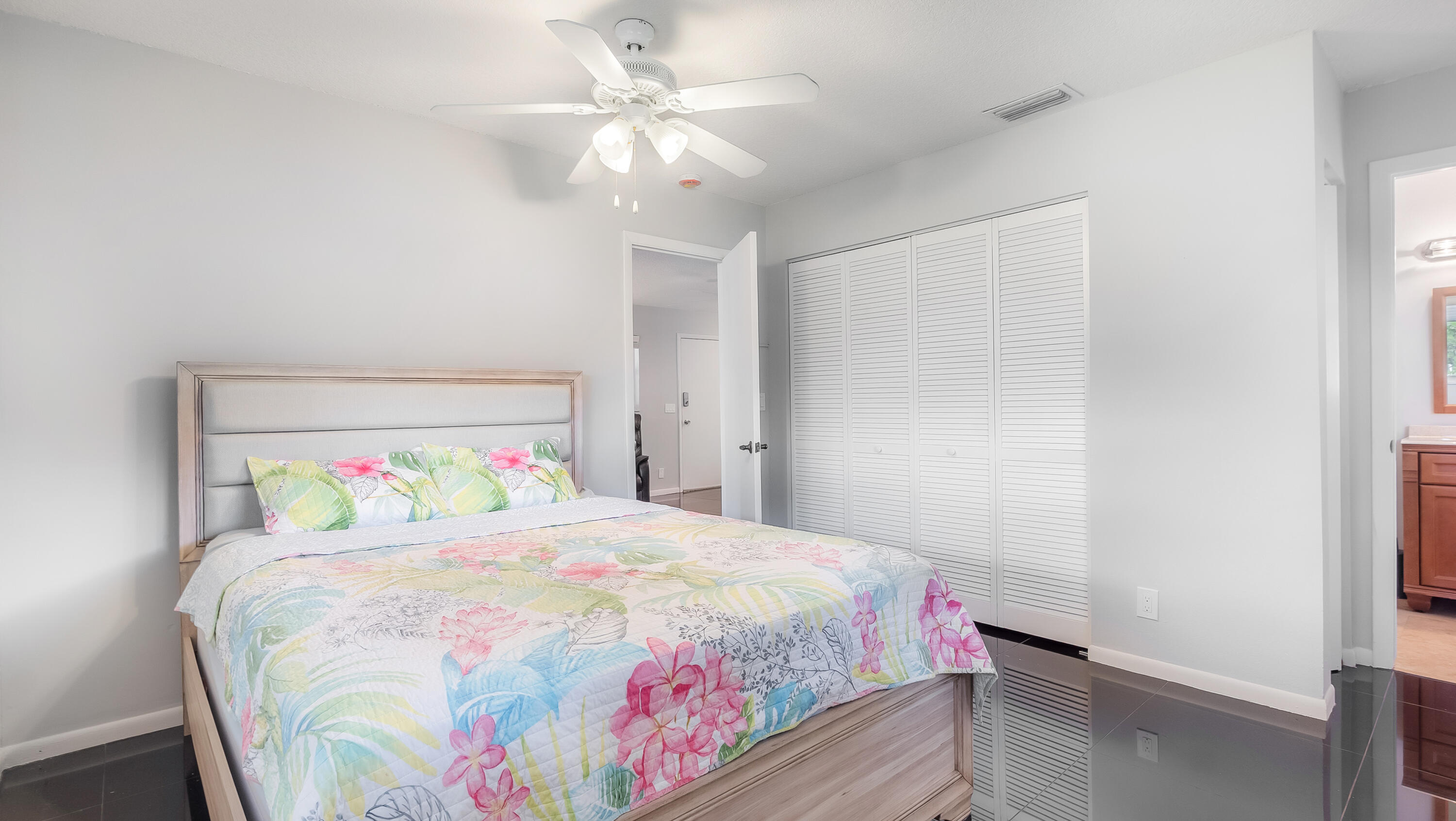 131 Mockingbird Lane Delray Beach, FL 33445 - Photo 21 of 29 a bedroom with a bed and a chandelier