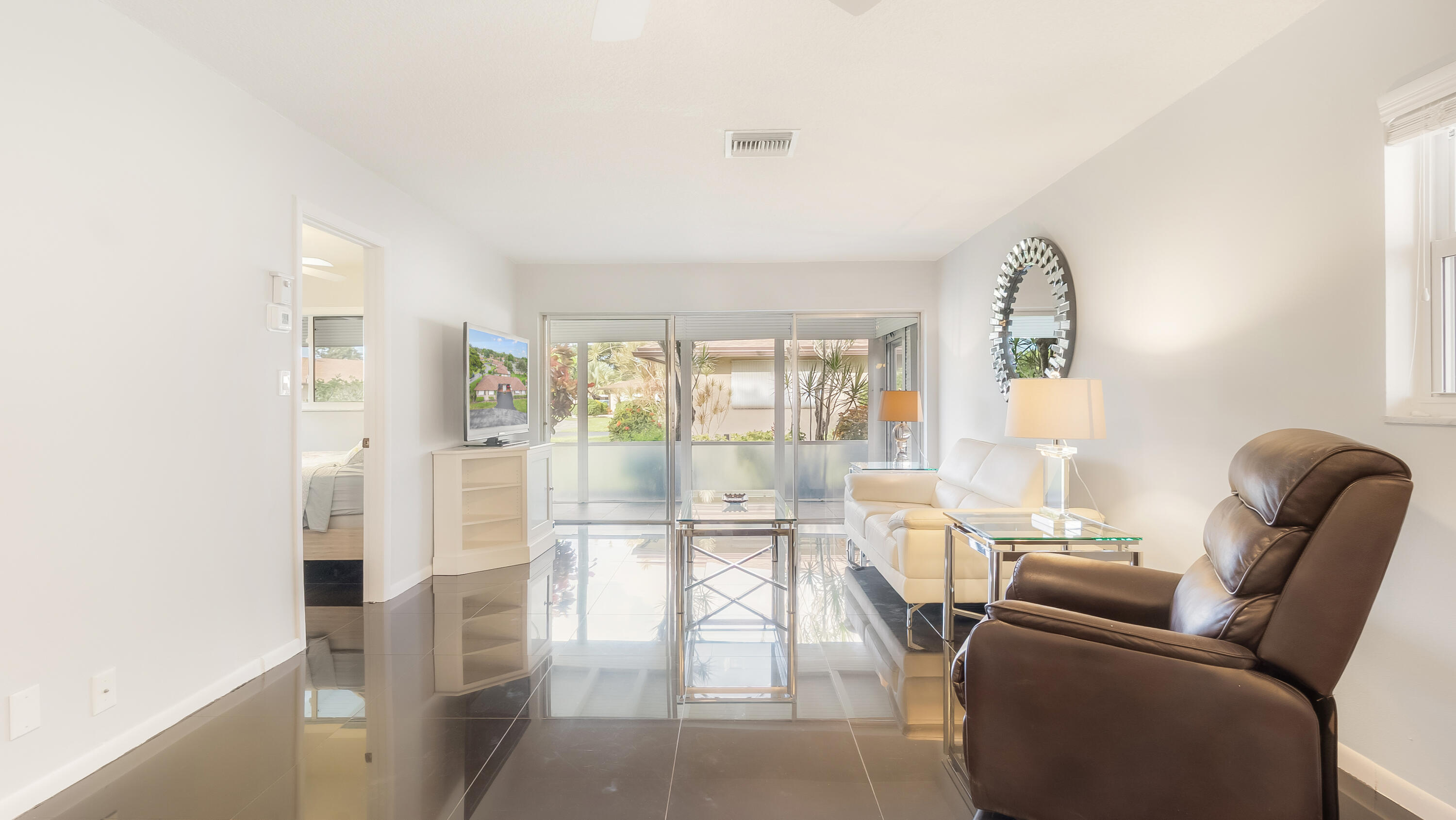 131 Mockingbird Lane Delray Beach, FL 33445 - Photo 4 of 29 a living room with furniture and a floor to ceiling window