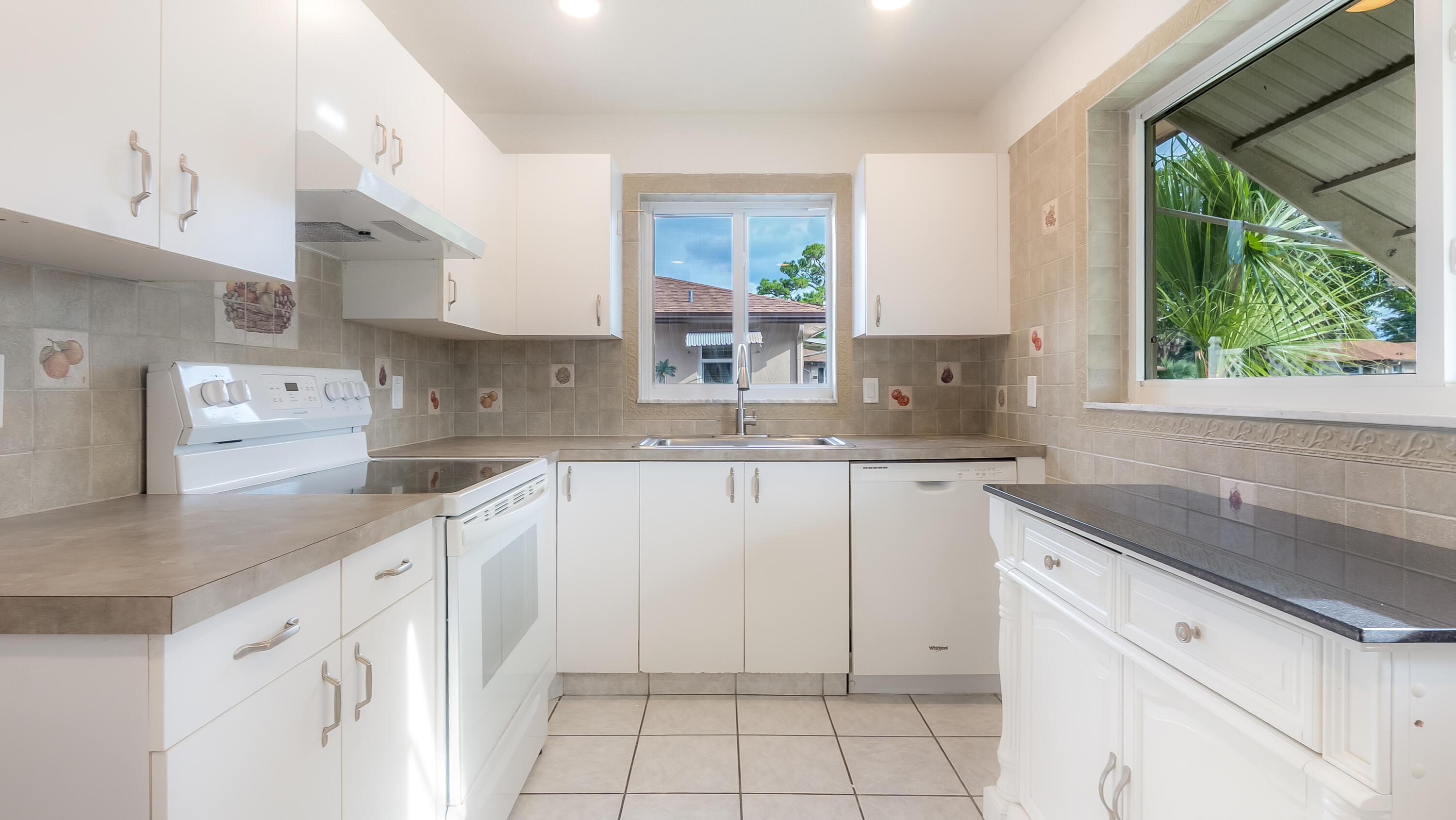 131 Mockingbird Lane Delray Beach, FL 33445 - Photo 9 of 29 a kitchen with white cabinets and a window