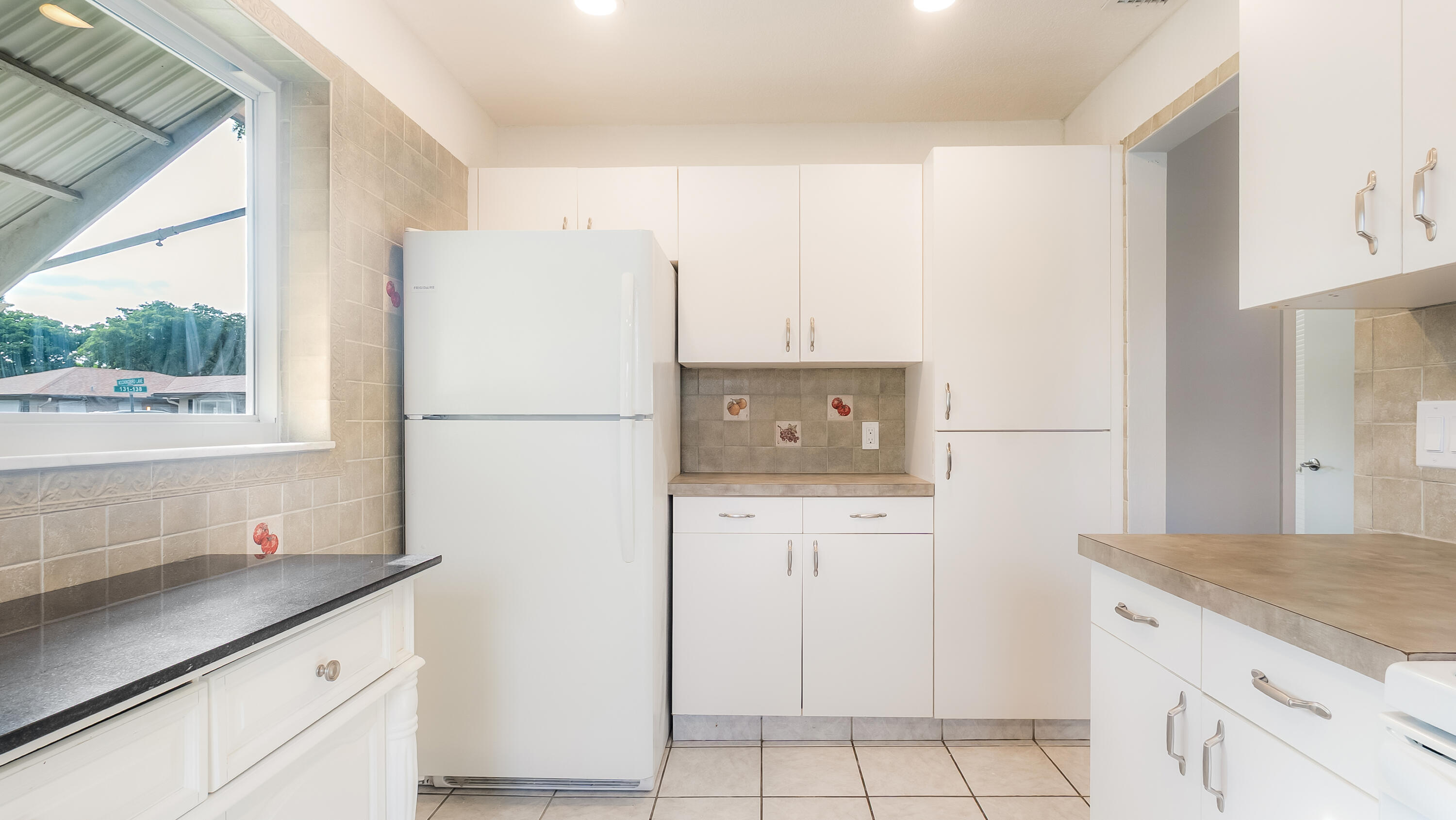 131 Mockingbird Lane Delray Beach, FL 33445 - Photo 10 of 29 a kitchen with stainless steel appliances a refrigerator sink and cabinets