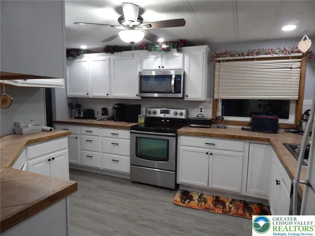 a kitchen with stainless steel appliances a stove sink microwave and cabinets