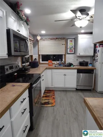 a kitchen with stainless steel appliances a sink stove top oven and cabinets