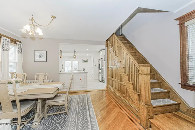 a kitchen with kitchen island granite countertop a sink a stove a refrigerator cabinets and chairs