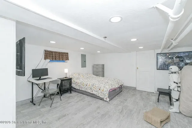 a view of an empty room with furniture and wooden floor