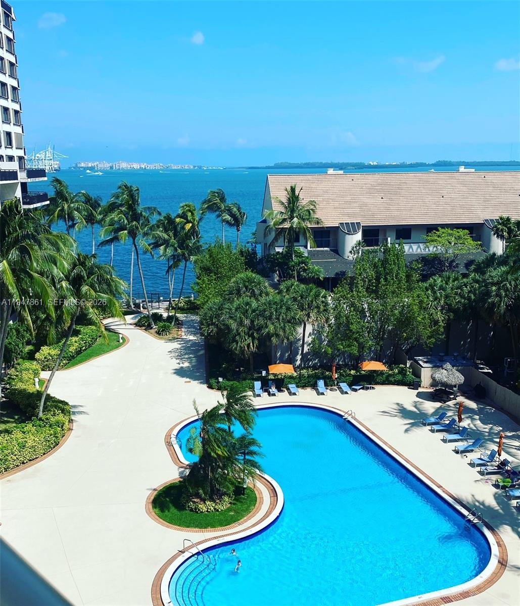 a view of a swimming pool with lawn chairs under an umbrella