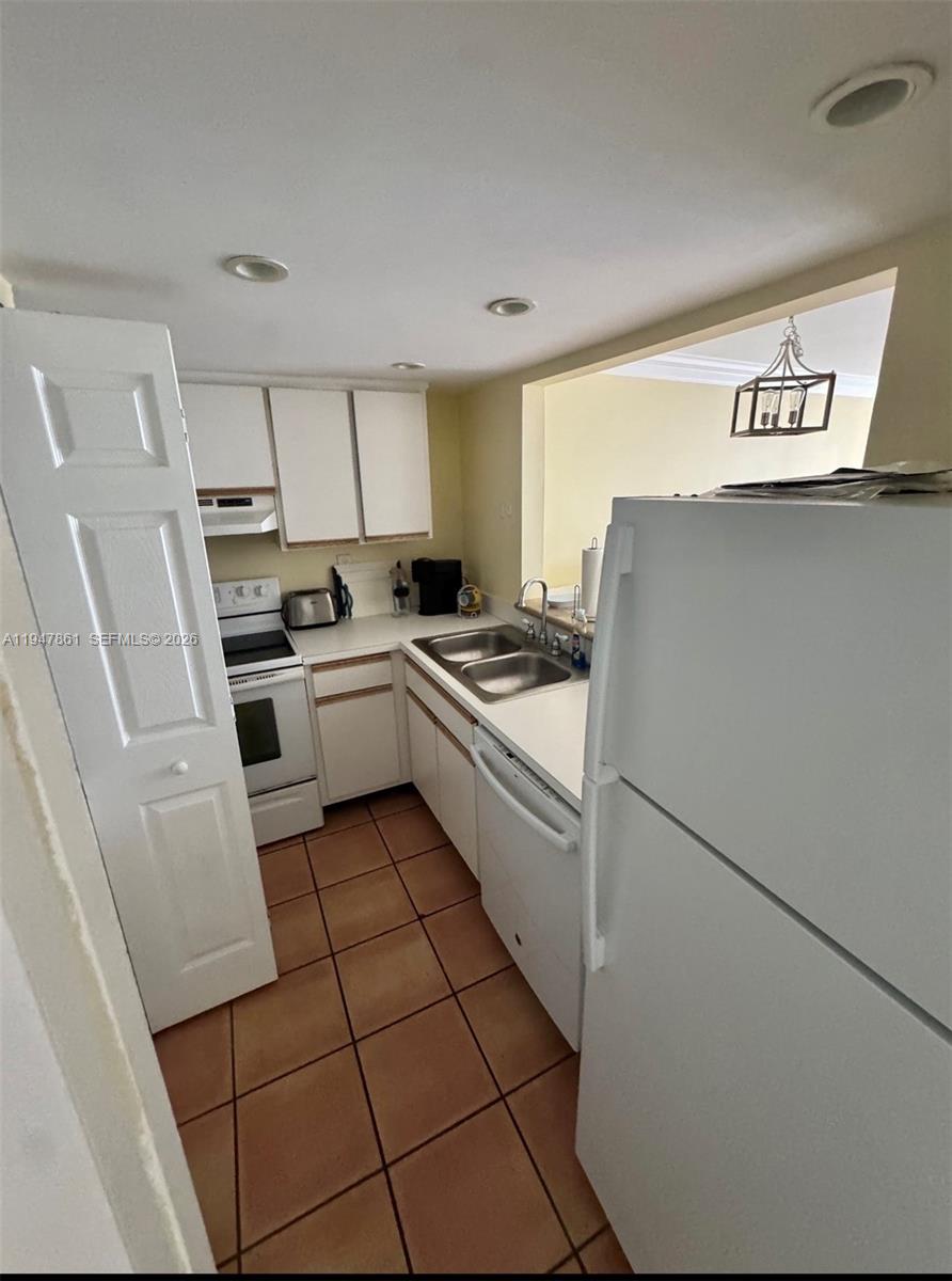 540 Brickell Key Drive, Unit 705 Miami, FL 33131 - Photo 17 of 38 a kitchen with granite countertop a refrigerator sink stove and cabinets