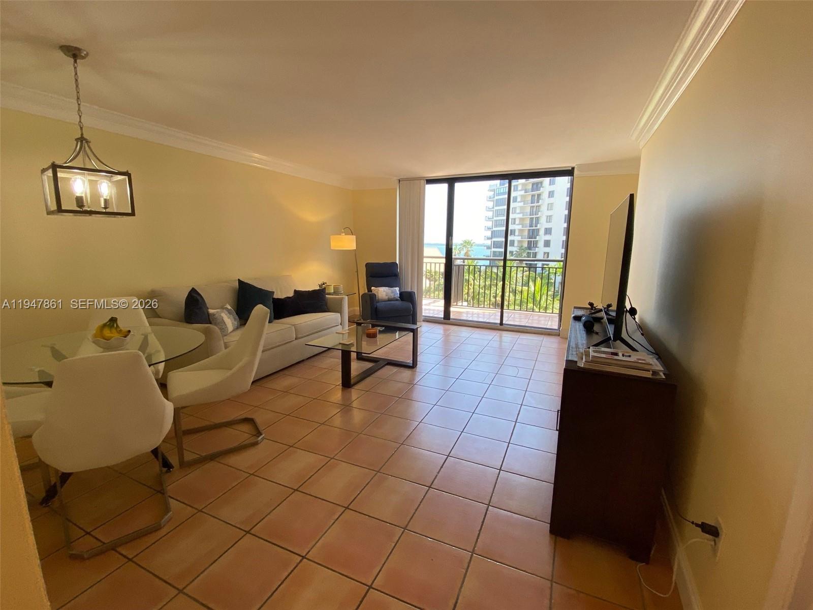 540 Brickell Key Drive, Unit 705 Miami, FL 33131 - Photo 18 of 38 a living room with furniture and a chandelier