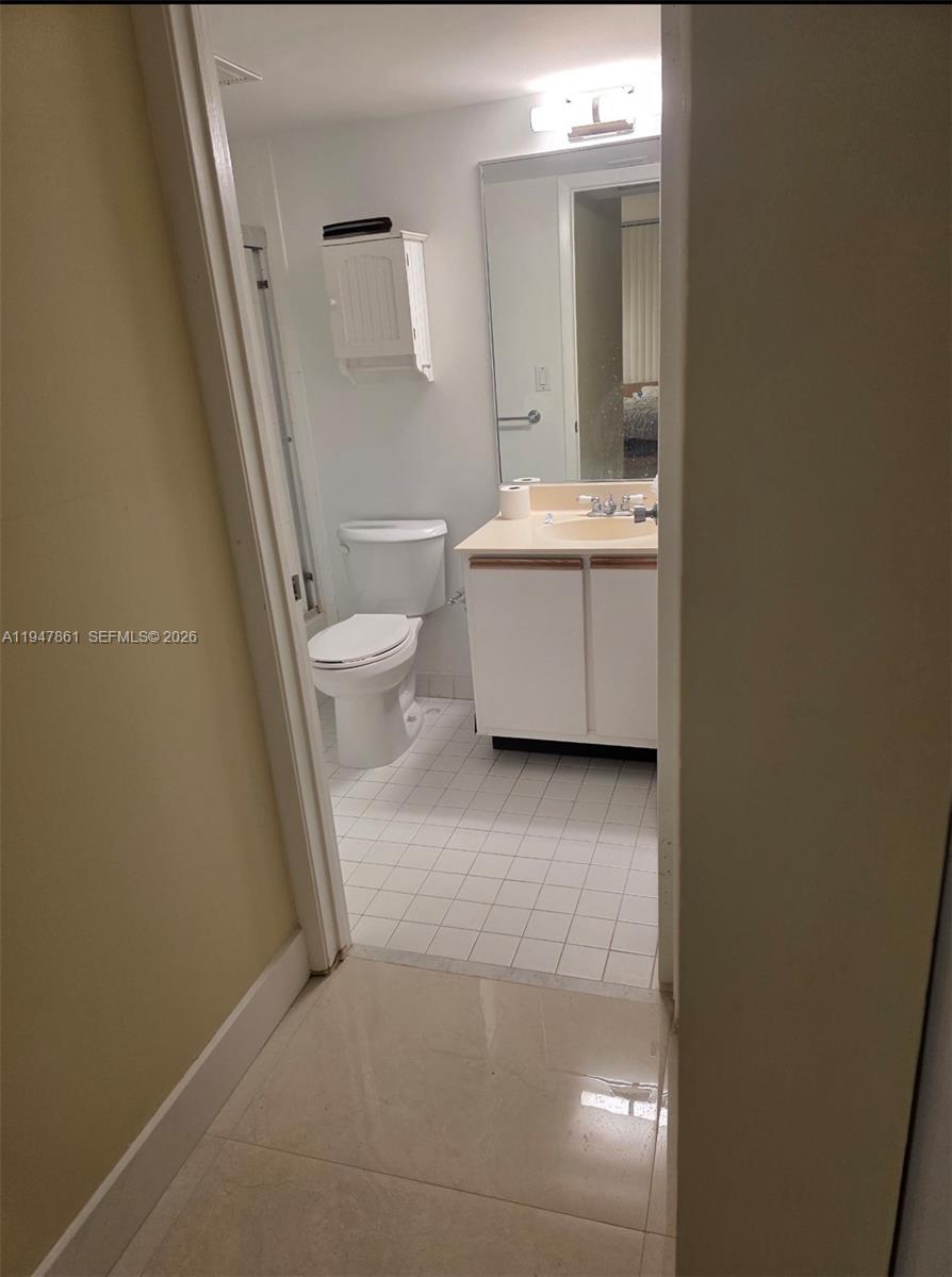 540 Brickell Key Drive, Unit 705 Miami, FL 33131 - Photo 28 of 38 a bathroom with a sink a toilet and a mirror