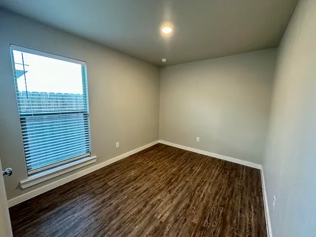 a view of a room with wooden floor and window