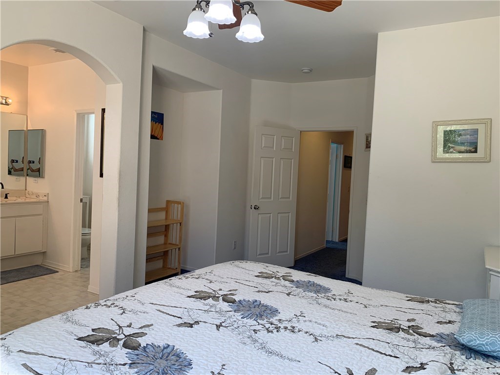 24817 Butterchurn Road Wildomar, CA 92595 - Photo 15 of 39 Master bedroom with arched doorway to master bath, a media niche that would make a great spot for built-ins, a huge walk-in closet, and a sliding glass door to the backyard (see other photo).