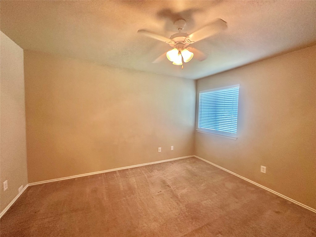 2624 Haselwood Lane Round Rock, TX 78665 - Photo 13 of 20 an empty room with a chandelier fan and windows