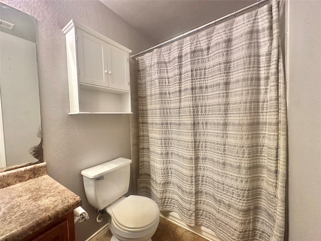 2624 Haselwood Lane Round Rock, TX 78665 - Photo 14 of 20 a white toilet sitting next to a shower curtain