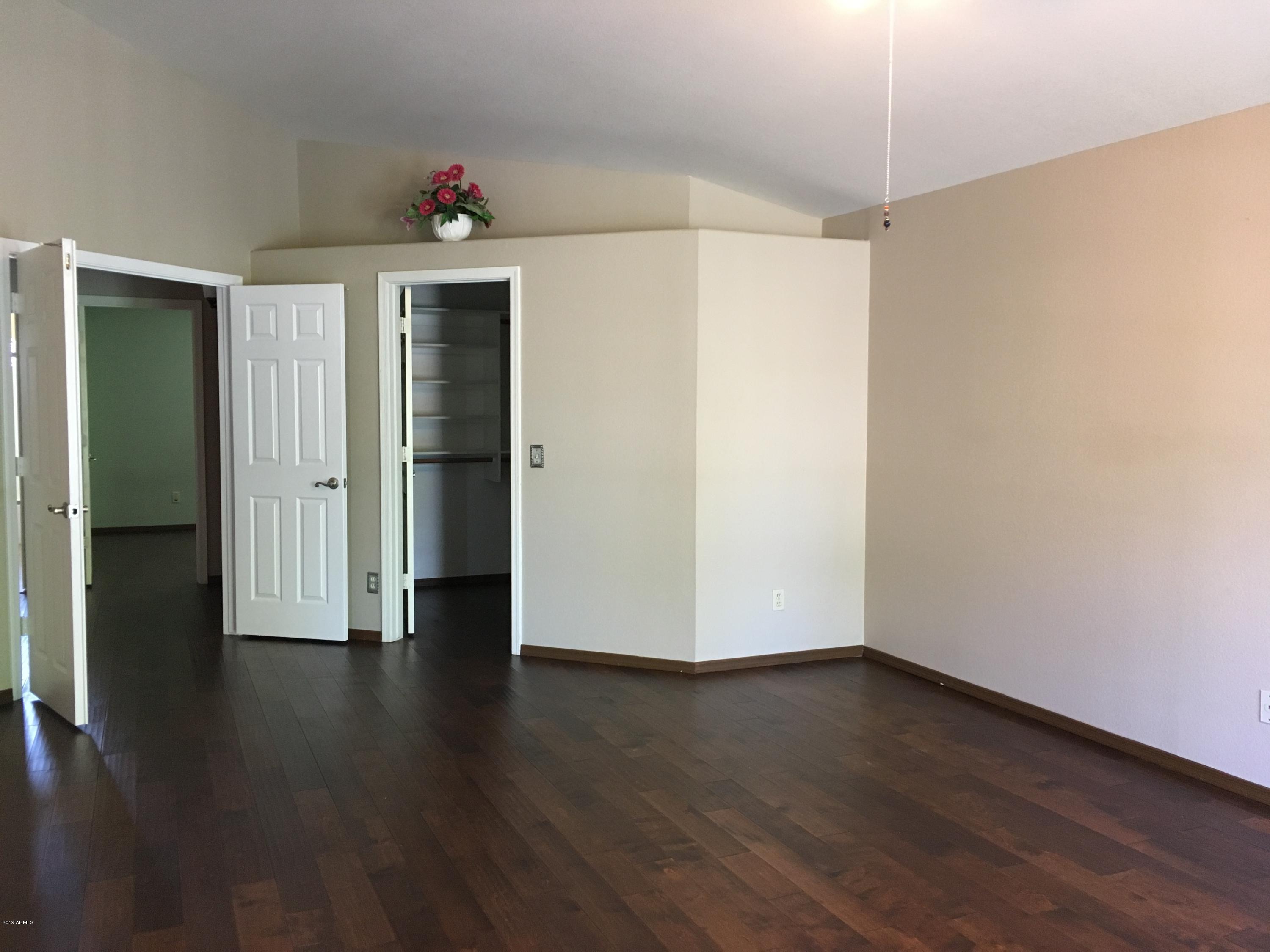 5956 East Phelps Road Scottsdale, AZ 85254 - Photo 21 of 29 an empty room with wooden floor and ceiling fan