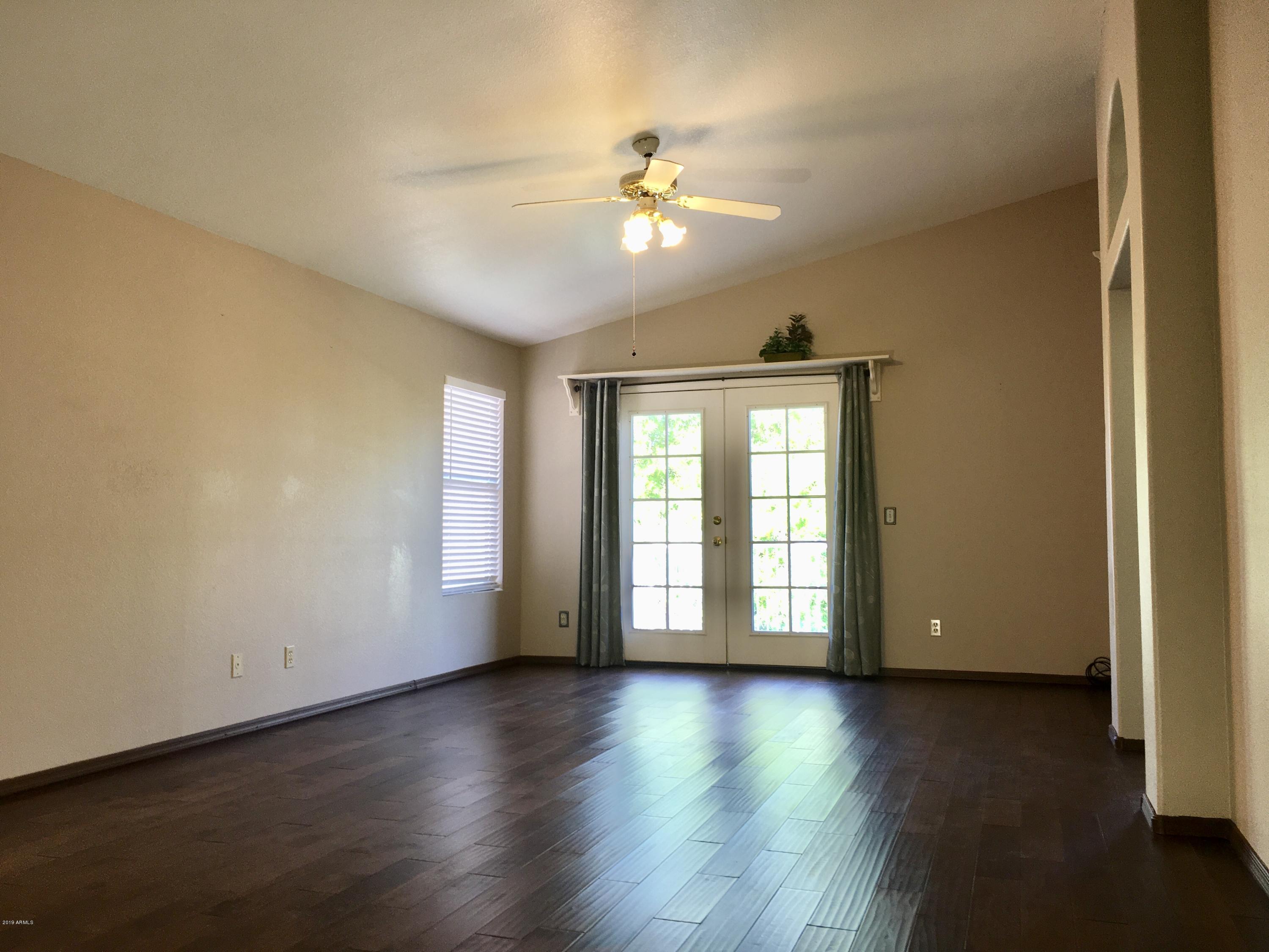 5956 East Phelps Road Scottsdale, AZ 85254 - Photo 3 of 29 a view of an empty room with wooden floor and a window