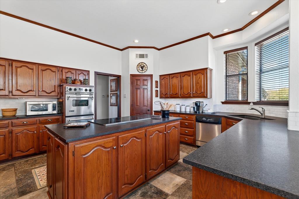 1500 Eden Ridge Celina, TX 75009 - Photo 10 of 40 a kitchen with stainless steel appliances granite countertop a sink stove and cabinets