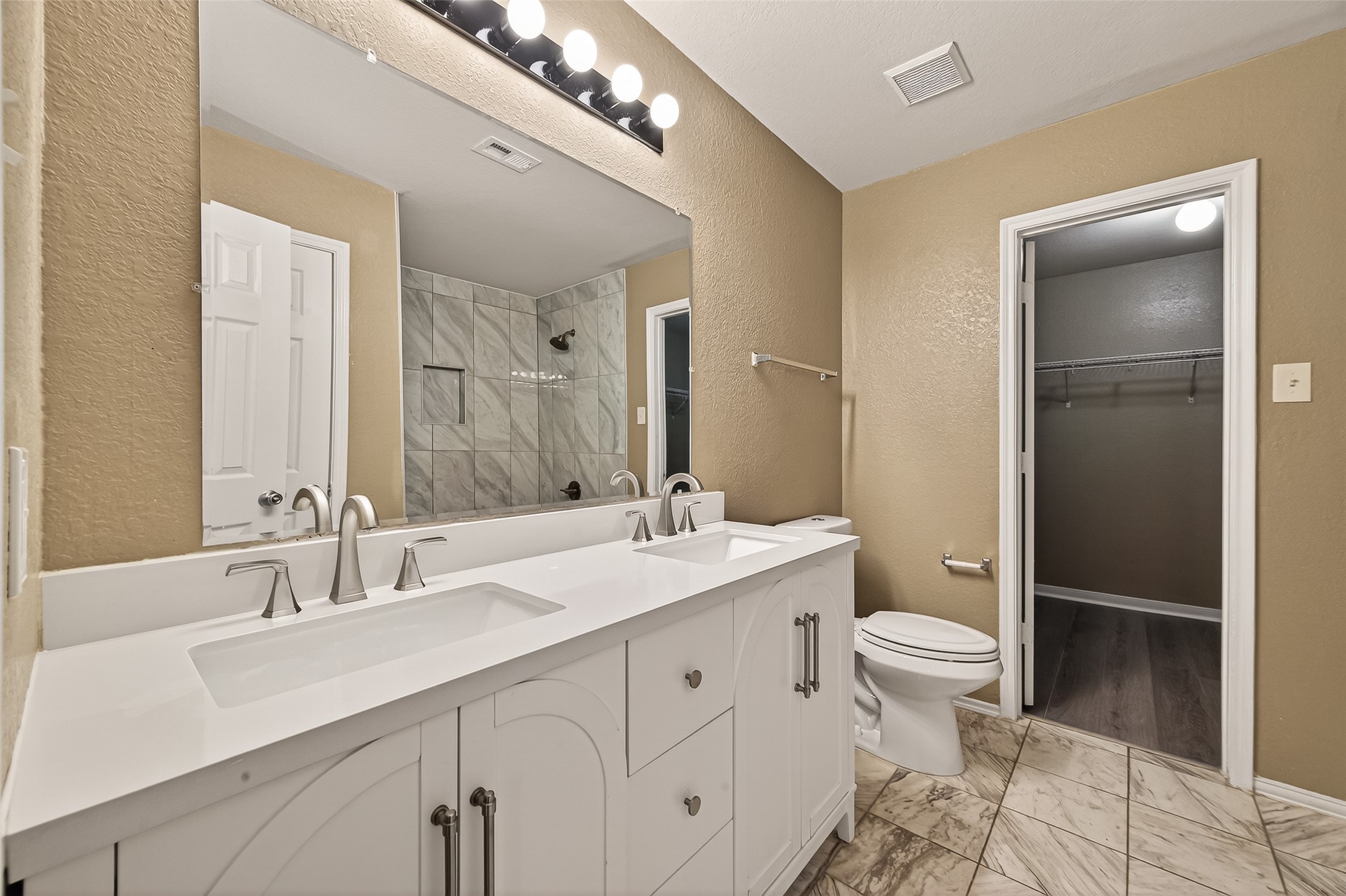 2918 Latch Lane Houston, TX 77038 - Photo 14 of 23 a bathroom with a double vanity sink a toilet and a mirror