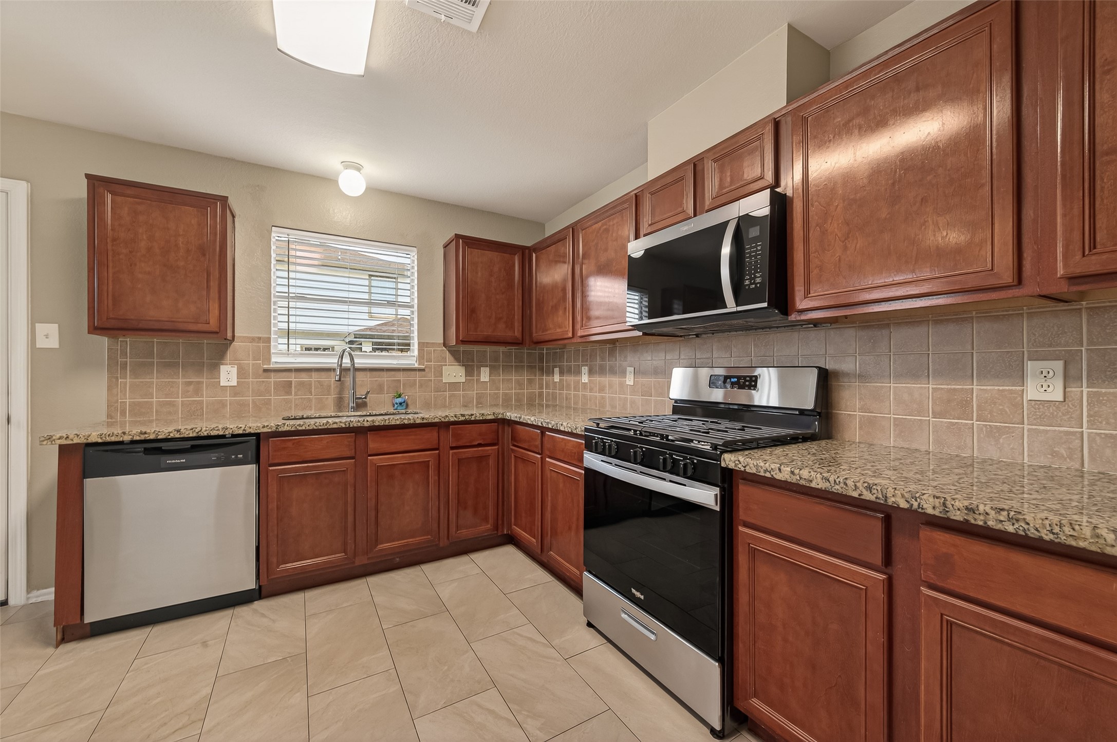 2918 Latch Lane Houston, TX 77038 - Photo 7 of 23 a kitchen with stainless steel appliances granite countertop a stove microwave and sink