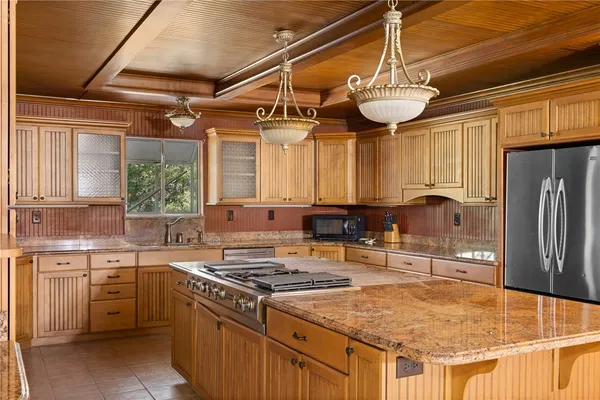 a kitchen with stainless steel appliances granite countertop a sink a stove and a refrigerator