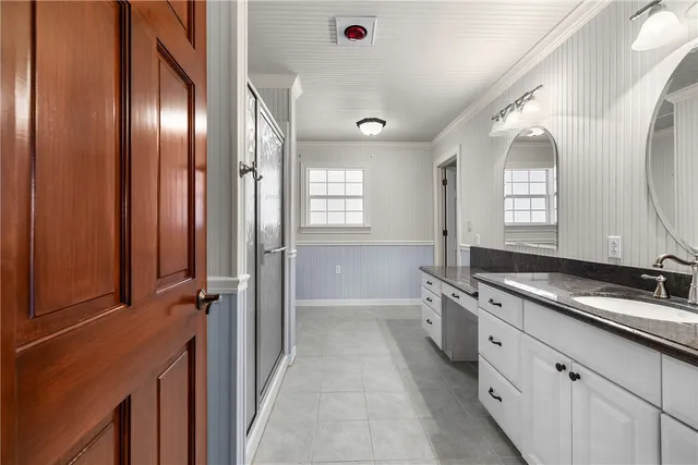 a bathroom with a double vanity sink and mirror with shower