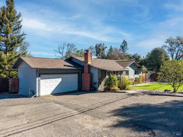 a front view of a house with a yard and potted plants