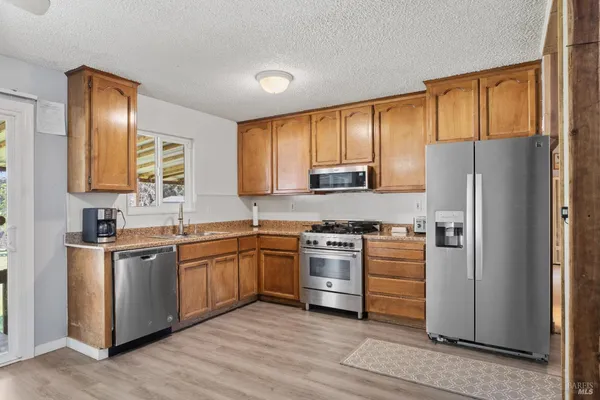 a kitchen with stainless steel appliances granite countertop a refrigerator stove and sink