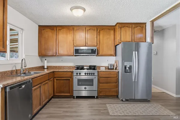 a kitchen with stainless steel appliances granite countertop a refrigerator stove and sink