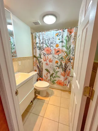 a bathroom with a toilet and a shower curtain