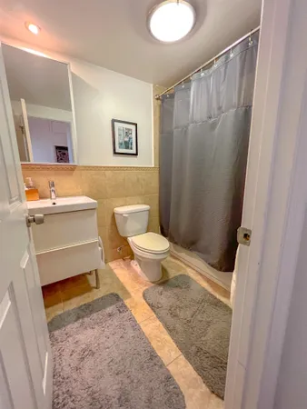 a bathroom with a sink a toilet a mirror and shower