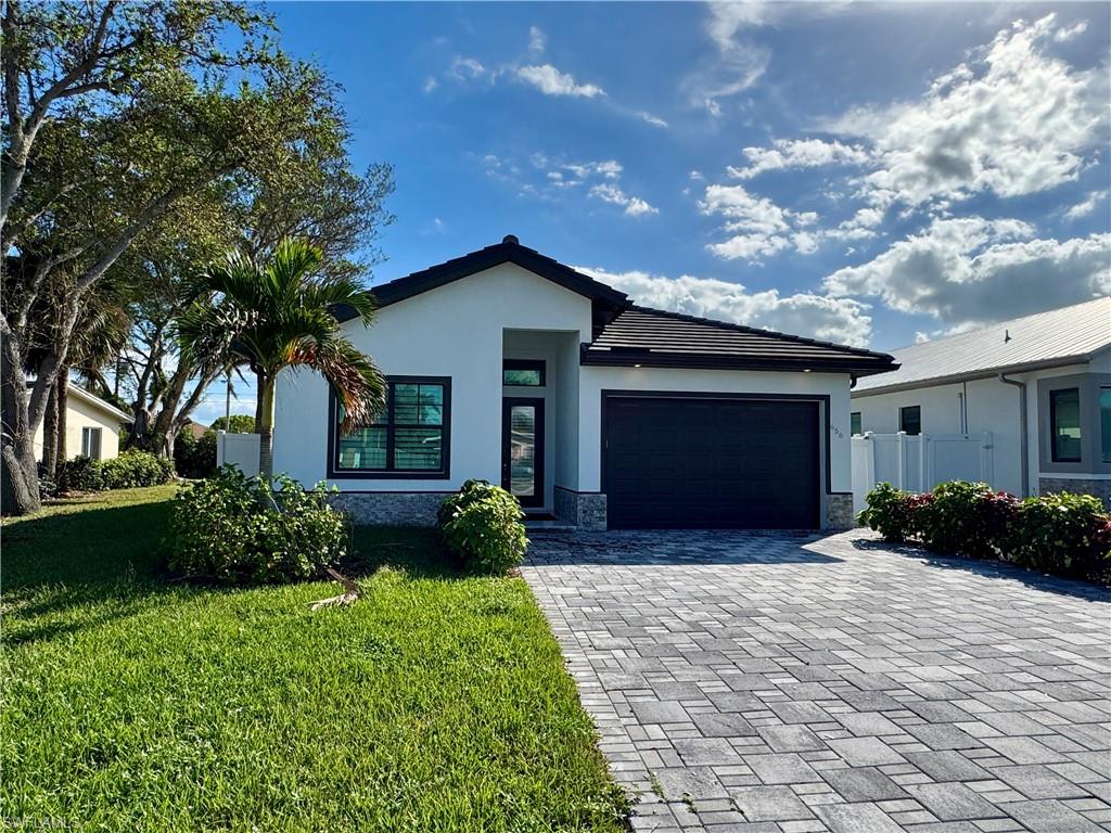 View of front of property with a front lawn and a 2-car garage