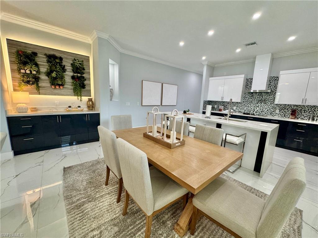 656 108th Avenue North Naples, FL 34108 - Photo 12 of 48 Bar featuring crown molding and light stone countertops