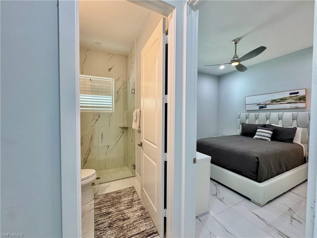 656 108th Avenue North Naples, FL 34108 - Photo 31 of 48 Bedroom with ceiling fan and full bathroom in hallway.