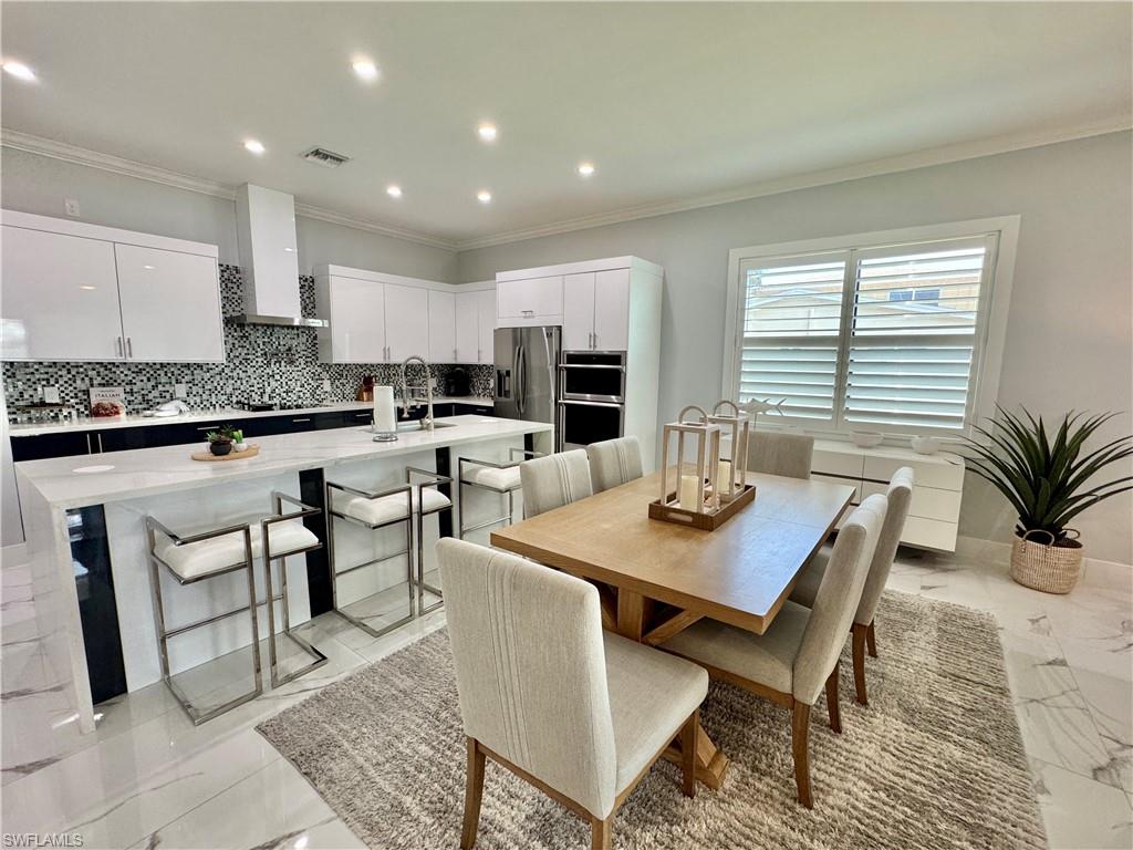 656 108th Avenue North Naples, FL 34108 - Photo 8 of 48 Dining area featuring ornamental molding