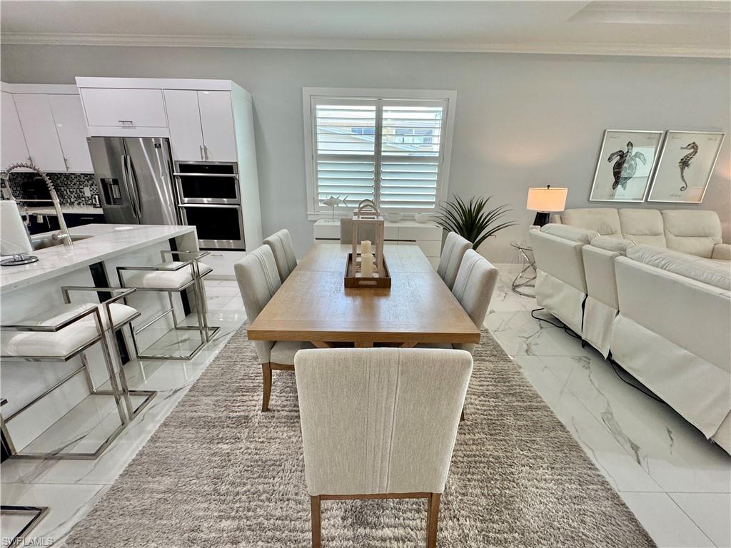 656 108th Avenue North Naples, FL 34108 - Photo 9 of 48 Dining area featuring crown molding and sink