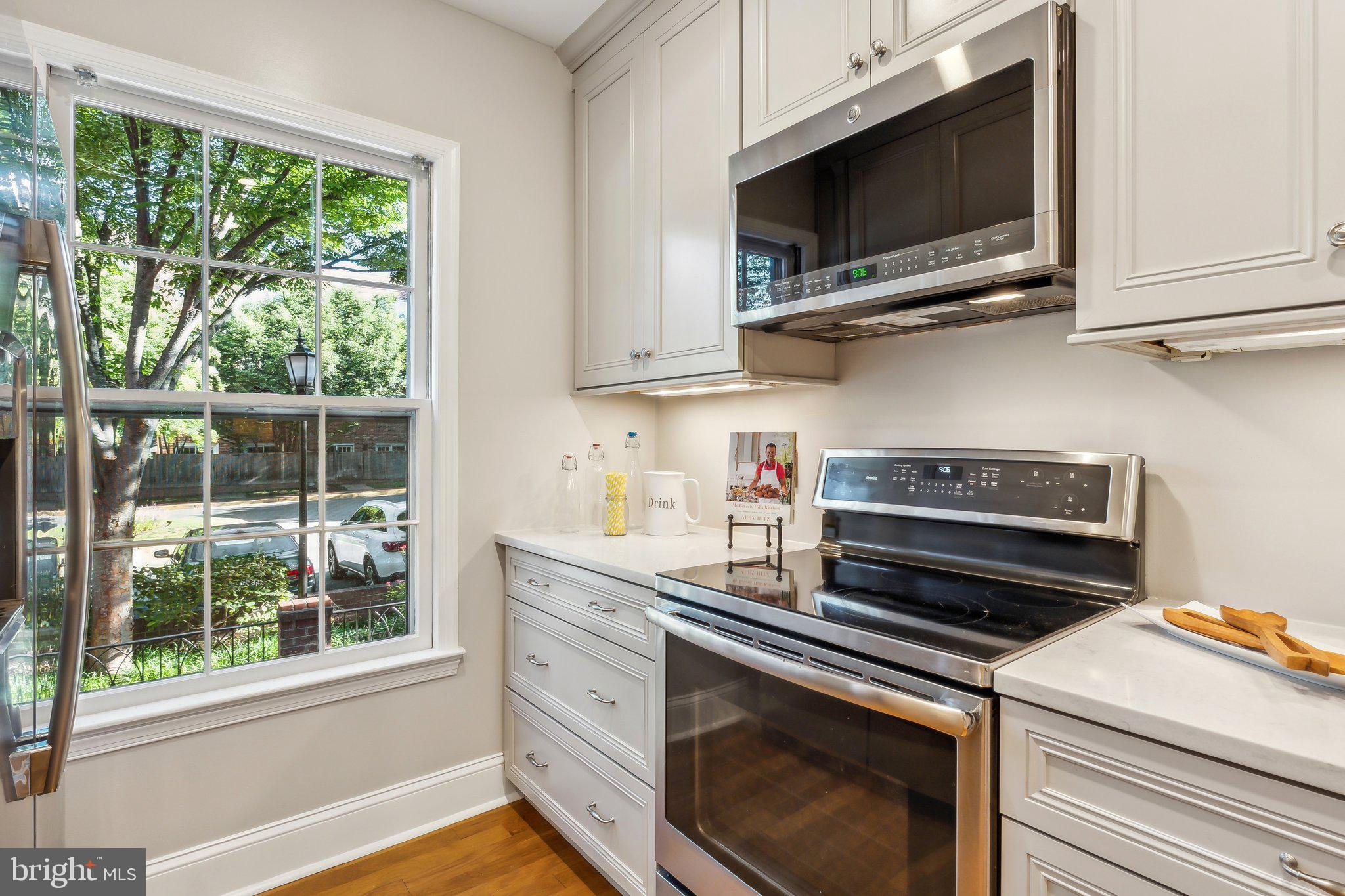 3205 Sutton Place Northwest, Unit A Washington, DC 20016 - Photo 12 of 44 a kitchen with stainless steel appliances a stove microwave and cabinets